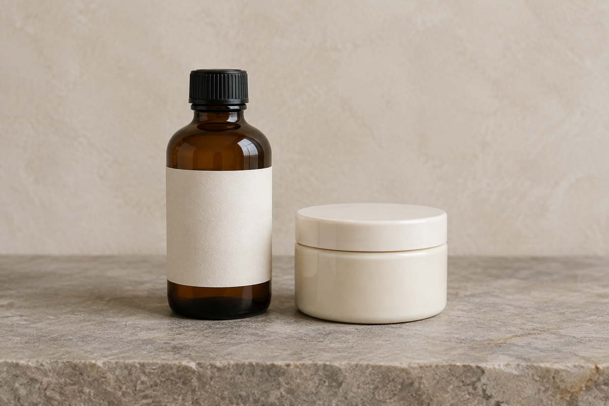 Geschlossene braune Glasflasche und heller Tiegel auf einer grauen Steinfläche.